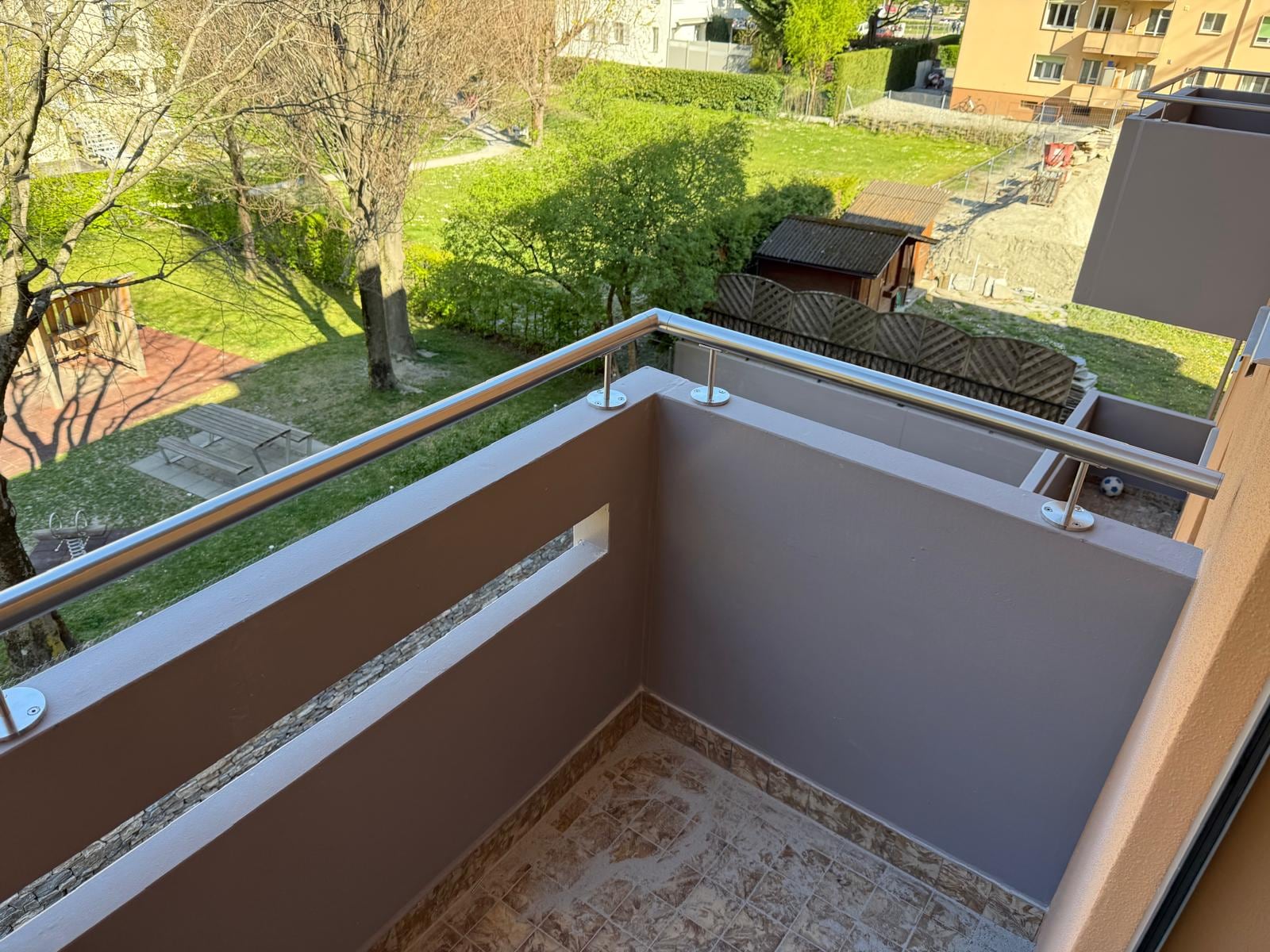 Balcon vu d’en haut : main courante inox sur potelets au-dessus du parapet — Epineys, Martigny (VS)