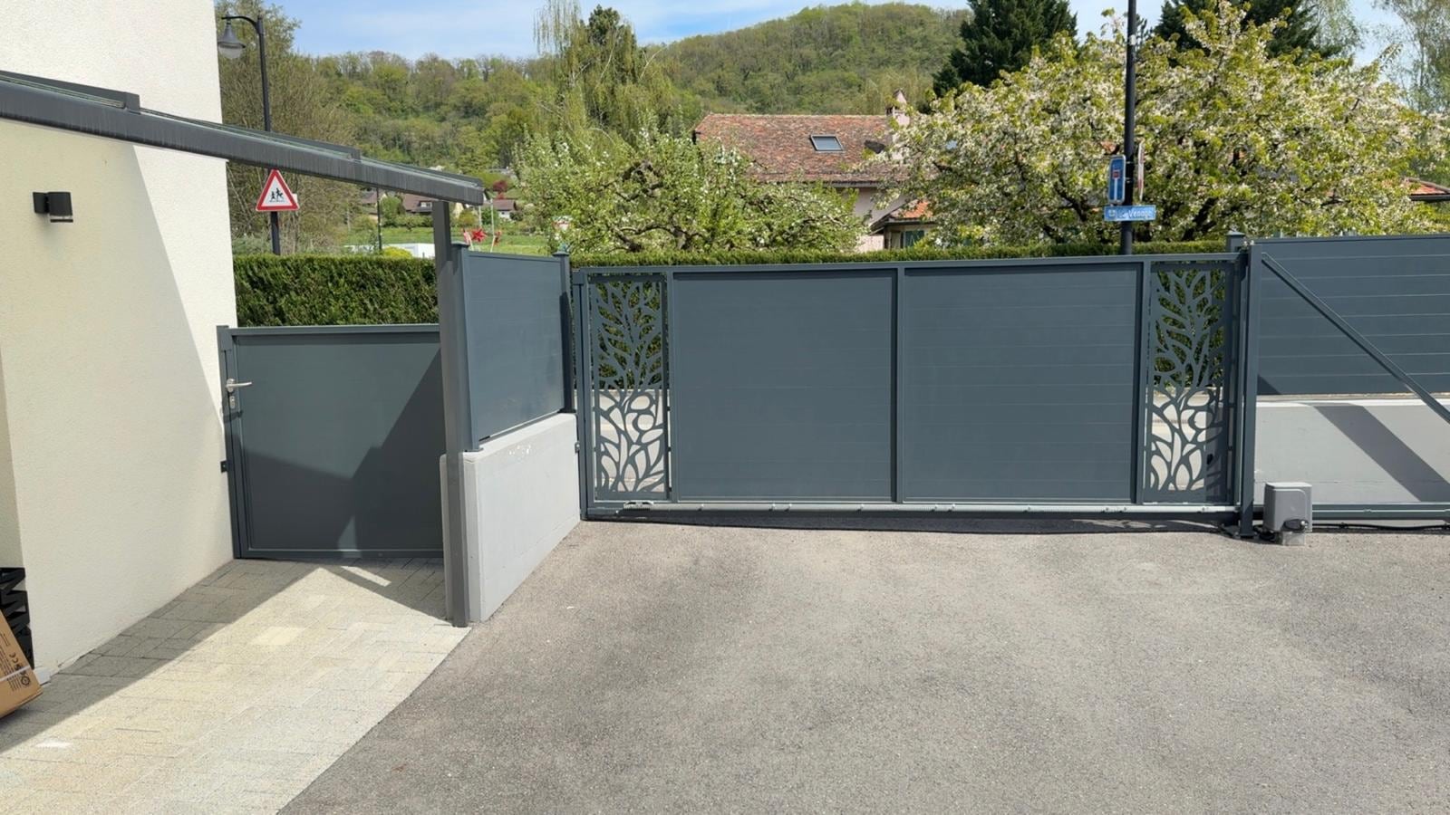 Portail fermé à panneaux ajourés à motif végétal, portillon à gauche — Eclepens (VD)